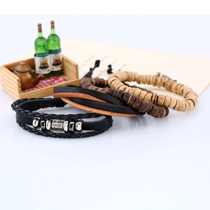Close-up of a 4-piece vintage leather set with braided cords and wooden beads for men