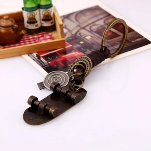Retro bronze skateboard keychain with woven leather strap on a warm vintage background