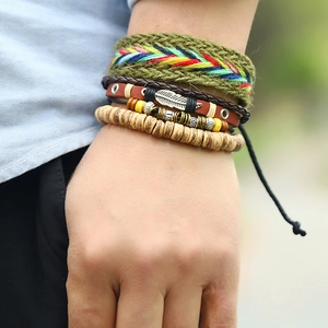 Detail shot of multi-layer leather braided bracelet with wooden beads and feather charm