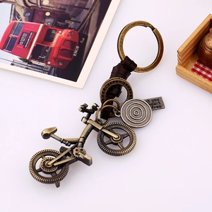 Vintage bronze bicycle keychain with brown woven leather strap and metal tag