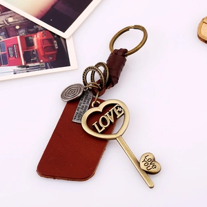 Vintage braided leather keychain with LOVE pendant and heart charm on white background