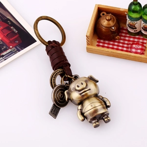 Porte-clés cochon vintage avec lanière en cuir tressé et finition en alliage de bronze