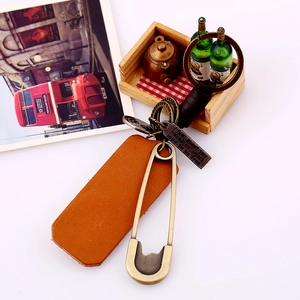 Retro hand-woven leather keychain with vintage safety pin and engraved metal tag