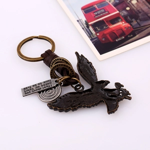 Vintage braided leather keychain featuring a bronze eagle pendant and engraved metal charms