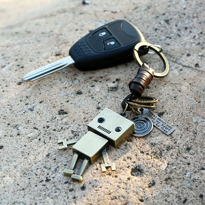 Vintage bronze robot keychain with brown leather wrap and engraved quote tag on stone