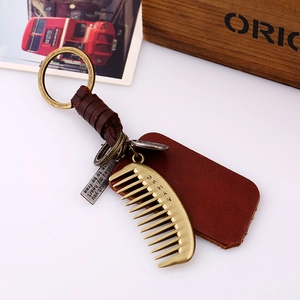 Vintage leather keychain with metal comb pendant and engraved tags in industrial style