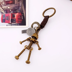 Retro industrial robot keychain with brown leather cord on a vintage postcard