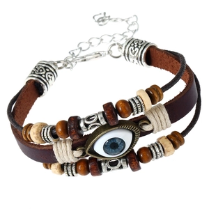 Dettaglio del bracciale multistrato in pelle boho con ciondolo occhio e perline in legno