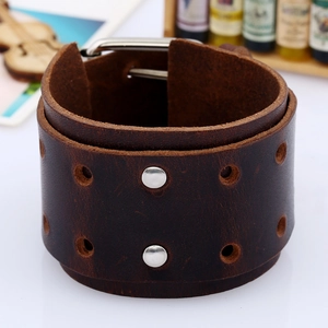 Detail of dark brown leather punk bracelet featuring silver rivets and buckle closure