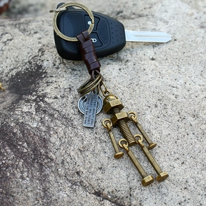 Industrial retro robot keychain with brown leather on rustic stone with car key