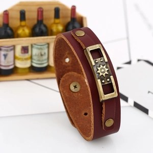 Vintage burgundy leather bracelet with antique brass sunburst emblem and rivet details