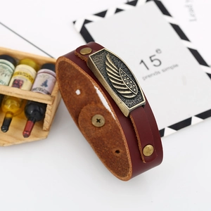 Vintage burgundy leather bracelet featuring a bronze wing charm and secure snap buttons