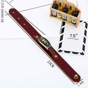 Punk style burgundy leather bracelet with bronze skull charms in a 45-degree angle view