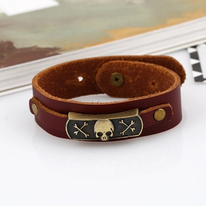 Punk brown leather bracelet featuring a vintage metal skull and crossbones relief