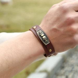 Vintage brown leather men's bracelet with brass skull studs and punk metal rivets