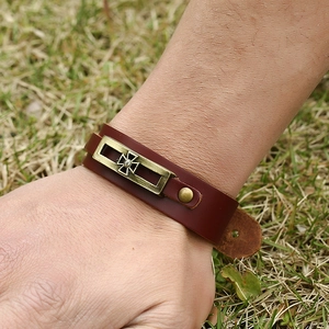 Vintage brown leather wristband featuring an iron cross bronze metal ornament