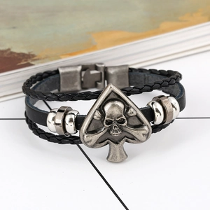 Macro-opname van herenarmband van leer met zilveren schedel en gevlochten koorden