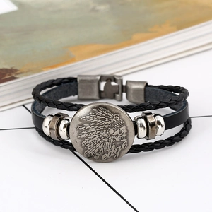 Macro-opname van leren herenarmband met gegraveerde schedel en veer op metalen bedel