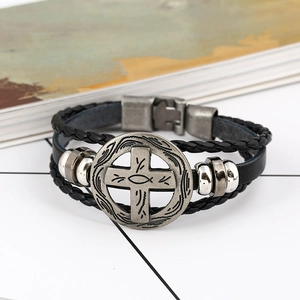 Detail van zwarte gevlochten leren armband met een zilveren kruis en vis reliëf bedel