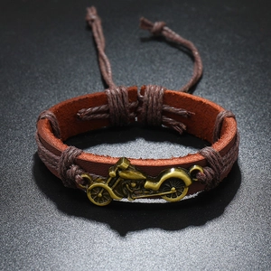 Detail of vintage brown leather bracelet with bronze motorcycle charm and adjustable cord
