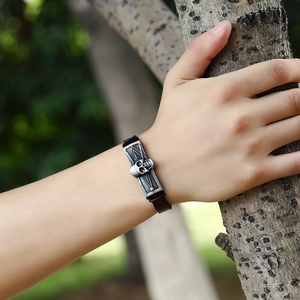 Men's punk vintage leather bracelet with skull metal plate on an outdoor natural background