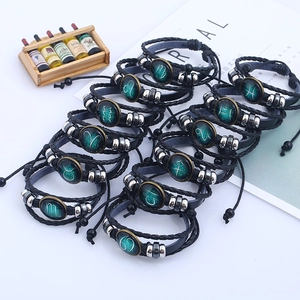 Set di dodici braccialetti zodiacali in pelle intrecciata con ciondoli costellazione in vetro