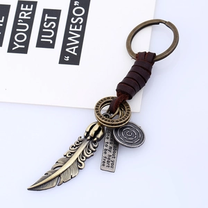 Vintage braided leather keychain with bronze feather and engraved metal pendants