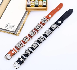 Détail de bracelets punk en cuir avec cinq croix métalliques et boucle en argent