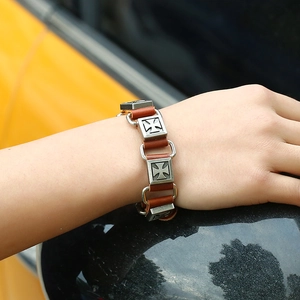 Détail d'un bracelet punk en cuir avec des croix en alliage argenté portées par un mannequin