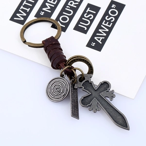 Vintage braided leather keychain featuring bronze cross and engraved metal bar charm