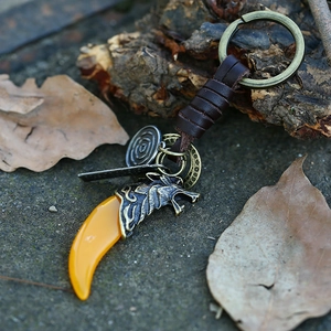 Vintage braided leather keychain with resin wolf tooth pendant and bronze wolf head charm