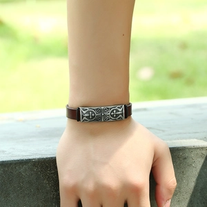 Men's retro brown leather bracelet with vintage silver cross metal plate on male wrist
