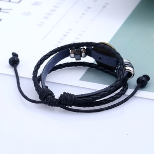 Dettaglio del bracciale multistrato in pelle nera con perline di metallo e nodo scorsoio regolabile