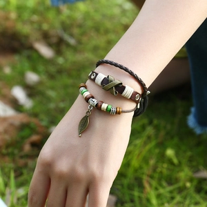 Multilayer leather bracelet set with bronze leaf pendant and woven straps in nature scene