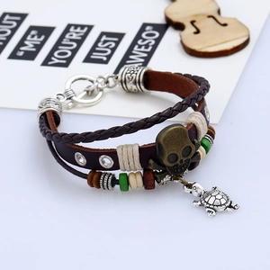 Retro punk multilayer leather bracelet with skull and turtle charms on a white background
