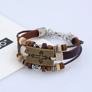 Retro multilayer leather beaded bracelet with bronze cross charm on a white background