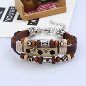 Detail of multilayer vintage leather bracelet featuring wooden beads and star engraved charm