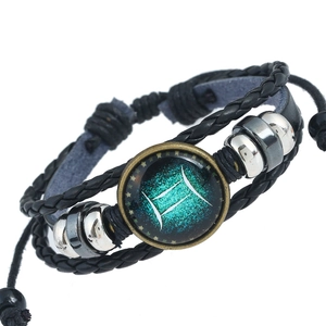 Dettaglio del bracciale in pelle intrecciata con segno Gemelli e perline metalliche