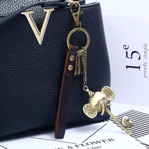 Vintage bronze elephant leather keychain with Love You engraving on a blue handbag