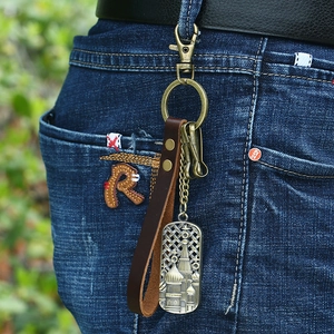 Vintage brown leather keychain with bronze alloy ring and Russian relief pendant on jeans