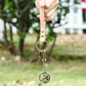 Vintage leather keychain with embossed bronze dragon pendant and peach pink hand strap