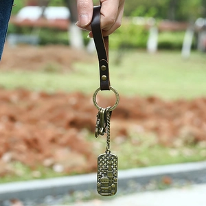 Vintage bronze alloy keychain with leather strap and embossed religious pendant charm