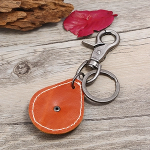 Retro punk genuine leather skull keychain with bronze lobster clasp on a rustic wooden desk