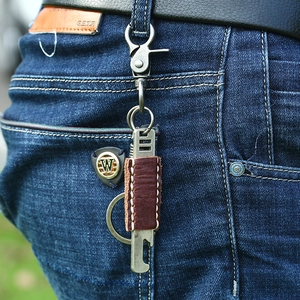 Vintage Leder Schlüsselanhänger mit Flaschenöffner am Gürtel einer Jeans Hose hängend