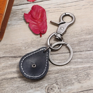 Vintage black leather keychain with white stitching and gunmetal lobster clasp on wood