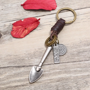 Retro bronze keychain with woven leather strap, shovel charm and engraved metal pendant