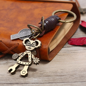 Retro punk gear robot keychain with brown leather wrap on vintage notebook background