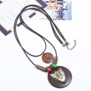 Ethnic multilayer necklace with Hamsa hand and cross pendant on brown wooden discs