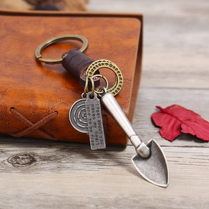 Retro leather keychain set with woven strap and vintage spade charms on leather notebook