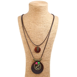 Vintage bronze dragon pendant long necklace with wooden beads and Hamsa hand on a mannequin